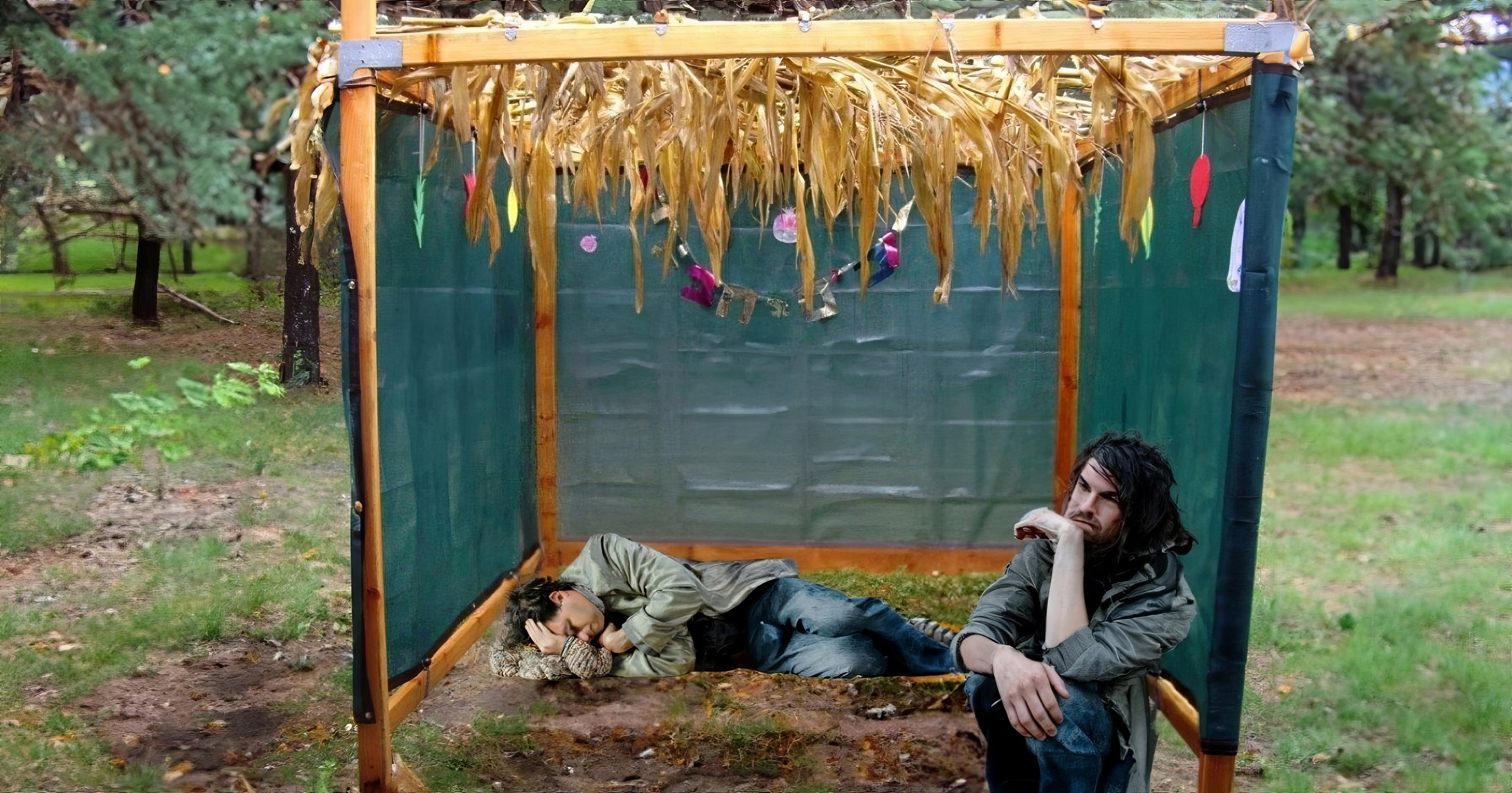 A sukkah with homeless looking peole in it.